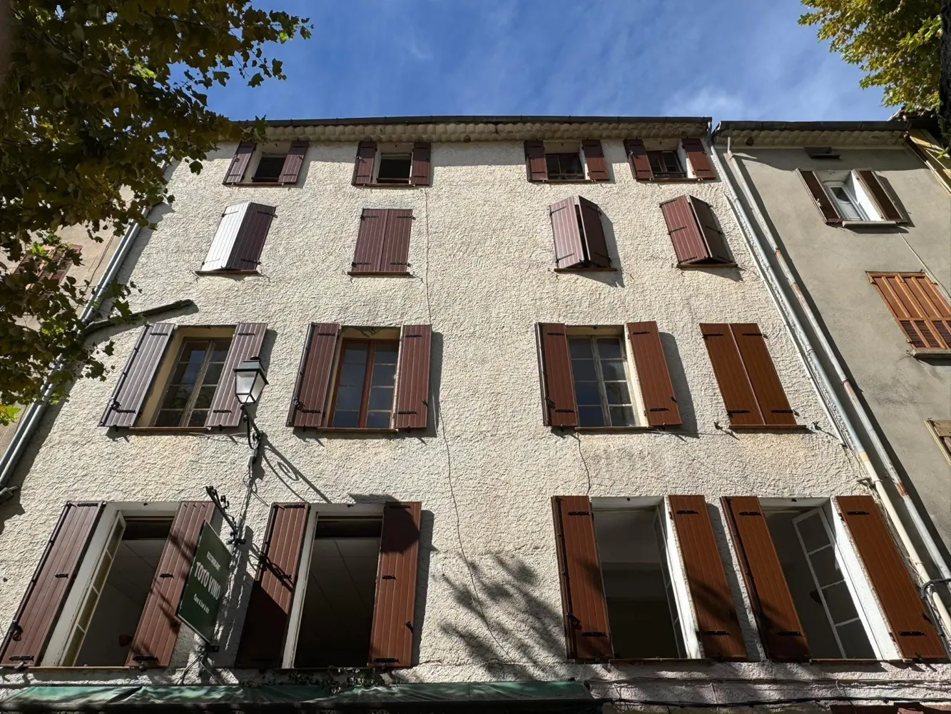 Volets battants marron installés sur une façade de village
